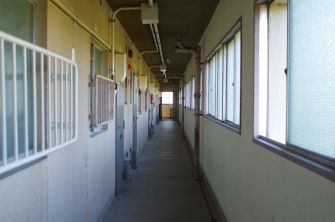 A corridor inside a jail facility with cells on either side.