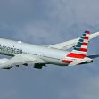 American Airlines passenger plane in flight against a cloudy sky. American Airlines passenger plane in flight against a cloudy sky.