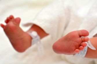 Feet of a newborn baby with identification wristbands.