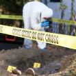 A forensic investigator collecting evidence at a crime scene marked with "DO NOT CROSS" tape. A forensic investigator collecting evidence at a crime scene marked with "DO NOT CROSS" tape.