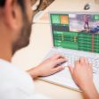 A person placing an online sports bet using a laptop. A person placing an online sports bet using a laptop.