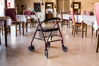 A walker placed in an empty dining area of a nursing home.