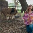 Carole Baskin at Big Cat Rescue with a lion in the background. Carole Baskin at Big Cat Rescue with a lion in the background.