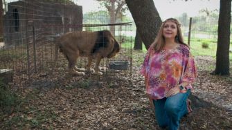 Carole Baskin at Big Cat Rescue with a lion in the background.