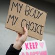 A hand holding a protest sign that reads "MY BODY MY CHOICE." A hand holding a protest sign that reads "MY BODY MY CHOICE."
