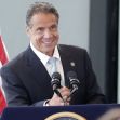 Former New York Governor Andrew Cuomo speaking at an event, with an American flag in the background. Former New York Governor Andrew Cuomo speaking at an event, with an American flag in the background.