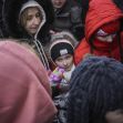 A group of Ukrainian asylum seekers, including children and adults, huddled together for warmth amid winter conditions while waiting for assistance. A group of Ukrainian asylum seekers, including children and adults, huddled together for warmth amid winter conditions while waiting for assistance.