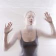 A blurred image of a young woman pressing her hands against a translucent surface, conveying a sense of isolation or entrapment. A blurred image of a young woman pressing her hands against a translucent surface, conveying a sense of isolation or entrapment.