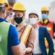 Workers wearing safety gear and masks are being screened for temperature at a workplace, highlighting health measures during the COVID-19 pandemic. Workers wearing safety gear and masks are being screened for temperature at a workplace, highlighting health measures during the COVID-19 pandemic.