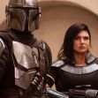 Gina Carano and a character in armor from 'The Mandalorian' standing together in a scene from the series. Gina Carano and a character in armor from 'The Mandalorian' standing together in a scene from the series.