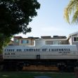 A vintage rail tank car labeled "Union Oil Company of California" located near residential buildings. A vintage rail tank car labeled "Union Oil Company of California" located near residential buildings.