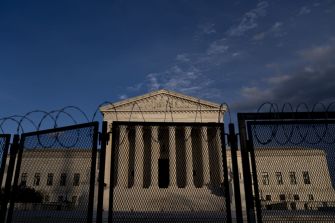 The exterior of the U.S. Supreme Court building, partially fenced with barbed wire.