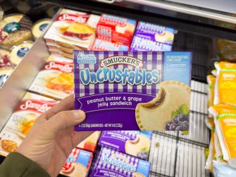 Smucker's Uncrustables peanut butter and grape jelly sandwich packaging displayed in a grocery store.