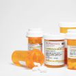 Several prescription pill bottles on a white surface. Several prescription pill bottles on a white surface.