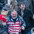 A man in a red, white, and blue hoodie, appearing emotional while surrounded by a crowd during the January 6 Capitol riot. A man in a red, white, and blue hoodie, appearing emotional while surrounded by a crowd during the January 6 Capitol riot.