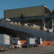 A cargo ship at dock with trucks unloading aluminum shipments. A cargo ship at dock with trucks unloading aluminum shipments.