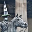 A statue wearing a traffic cone hat and a face mask, symbolizing protests against racial injustice. A statue wearing a traffic cone hat and a face mask, symbolizing protests against racial injustice.