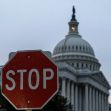 A stop sign in the foreground with the U.S. Capitol building in the background during dusk. A stop sign in the foreground with the U.S. Capitol building in the background during dusk.