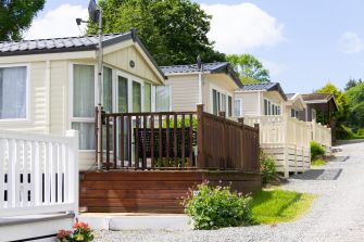 Row of mobile homes with porches in a residential area.