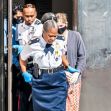 A woman in police custody is led away by officers in the Cayman Islands, following her arrest for violating COVID-19 quarantine protocols. A woman in police custody is led away by officers in the Cayman Islands, following her arrest for violating COVID-19 quarantine protocols.