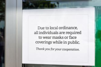 Sign informing the public about local ordinance requiring masks or face coverings in public.