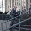 A man in a suit walking up the steps of a building, presumably related to a legal case. A man in a suit walking up the steps of a building, presumably related to a legal case.