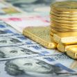 Stacks of gold bars and coins on a background of various currency notes. Stacks of gold bars and coins on a background of various currency notes.