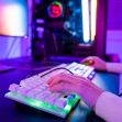 A person using a backlit keyboard and computer in a colorful gaming setup. A person using a backlit keyboard and computer in a colorful gaming setup.
