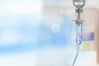 IV bag in a medical setting against a blurred background.
