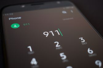Image of a smartphone screen displaying the emergency number 911 on the dialing interface.