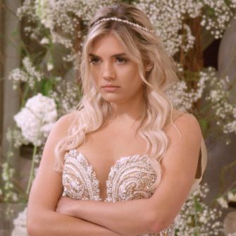 Contestant from the reality show "Love Is Blind" looking concerned while surrounded by floral decorations.