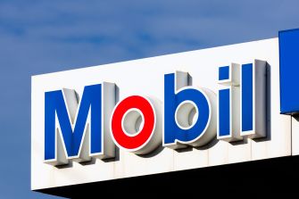 Signage of a Mobil gas station against a blue sky.