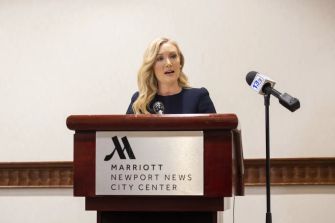 A woman speaking at a podium during a press conference about a school shooting incident in Newport News, Virginia.