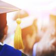 A graduate wearing a cap and gown at a graduation ceremony, with a focus on the cap's tassel. A graduate wearing a cap and gown at a graduation ceremony, with a focus on the cap's tassel.