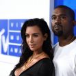 Kim Kardashian and Kanye West posing together at an event. Kim Kardashian and Kanye West posing together at an event.