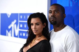 Kim Kardashian and Kanye West posing together at an event.