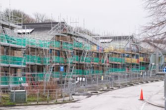 Construction site with scaffolding for multi-unit residential buildings.