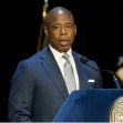 New York City Mayor Eric Adams speaking at a podium during a press conference. New York City Mayor Eric Adams speaking at a podium during a press conference.