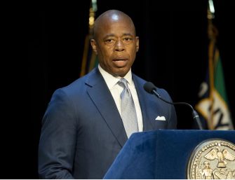 New York City Mayor Eric Adams speaking at a podium during a press conference.