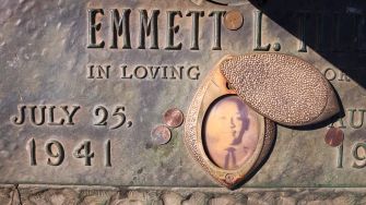 Memorial plaque for Emmett L. Till, featuring his name, date of birth, and an image surrounded by coins.
