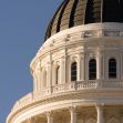 Close-up of the California State Capitol dome with American and California flags flying. Close-up of the California State Capitol dome with American and California flags flying.