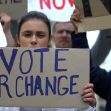 Protesters holding signs advocating for voting rights and reforms, with a focus on the message "VOTE FOR CHANGE". Protesters holding signs advocating for voting rights and reforms, with a focus on the message "VOTE FOR CHANGE".