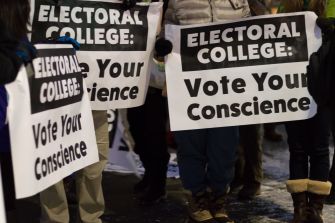 Demonstrators holding signs advocating for electors to "Vote Your Conscience" during a protest related to the Electoral College.