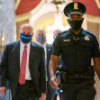 Postmaster General Louis DeJoy arriving at a congressional hearing with security personnel. Postmaster General Louis DeJoy arriving at a congressional hearing with security personnel.