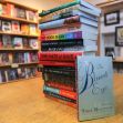A stack of books in a library setting, including "The Bluest Eye" by Toni Morrison prominently featured in the foreground. A stack of books in a library setting, including "The Bluest Eye" by Toni Morrison prominently featured in the foreground.