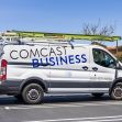 A Comcast Business service van parked in a lot, featuring the company logo and contact information. A Comcast Business service van parked in a lot, featuring the company logo and contact information.