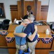 Two men embrace in a courthouse, symbolizing support and solidarity, against the backdrop of a legal setting. Two men embrace in a courthouse, symbolizing support and solidarity, against the backdrop of a legal setting.