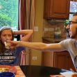 A candid moment at a dining table with two people sharing a lighthearted interaction. One person is playfully offering a drink to another, while the other looks amused and relaxed. The setting features a cozy kitchen with natural light and a view of the outdoors. A candid moment at a dining table with two people sharing a lighthearted interaction. One person is playfully offering a drink to another, while the other looks amused and relaxed. The setting features a cozy kitchen with natural light and a view of the outdoors.