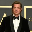 Brad Pitt posing at an awards ceremony in formal attire. Brad Pitt posing at an awards ceremony in formal attire.