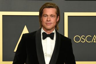 Brad Pitt posing at an awards ceremony in formal attire.